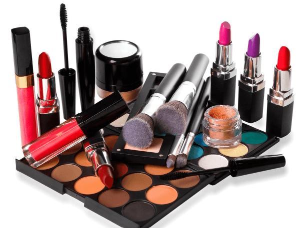 An assortment of makeup: lipsticks, mascara, brushes, and an eyeshadow palette