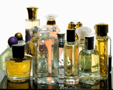 A cluster of assorted perfume bottles reflected on a glossy surface