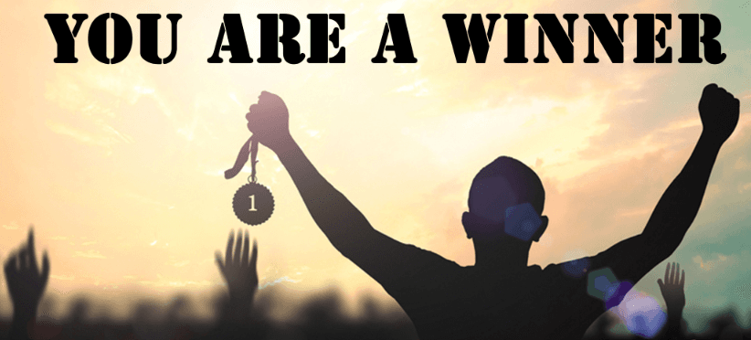 A silhouetted figure raising a first-place medal against a sunset sky, captioned 'You are a winner'